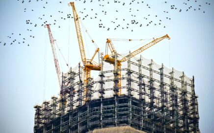 low angle photography of cranes on top of building