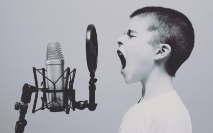 boy singing on microphone with pop filter