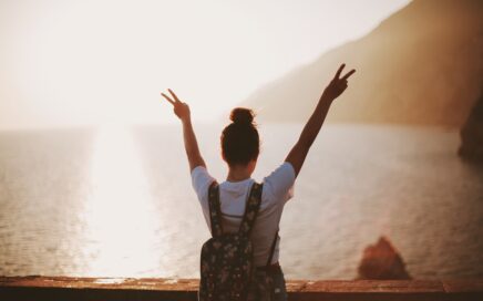 woman standing near seashore doing peace sign