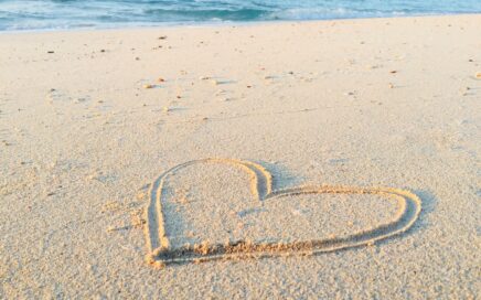 heart drawn on sand during daytime