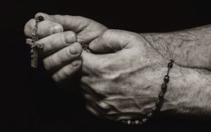 grayscale photo of person holding silver necklace