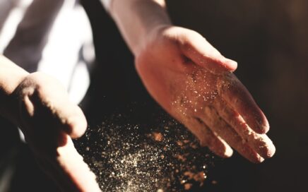 person's hand with dust during daytime