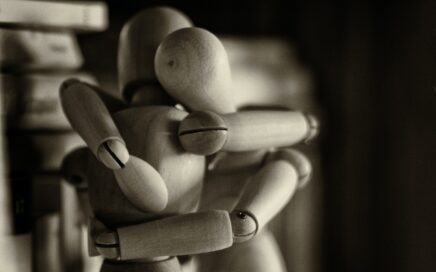 two wooden dummy hugging figures