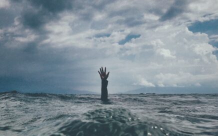 photo of person reach out above the water