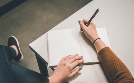 person writing on white paper