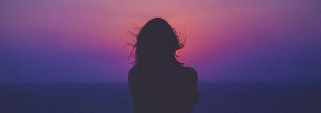 silhouette of a woman with pink and purple sky