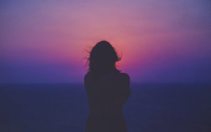 silhouette of a woman with pink and purple sky