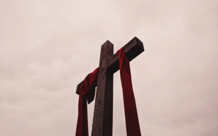 low angle view of cross with red garment