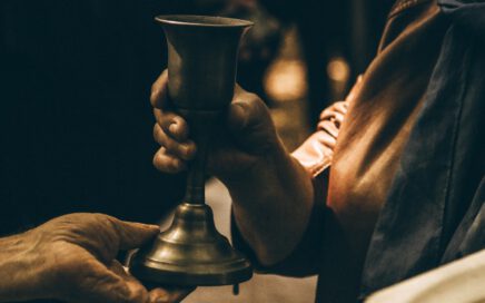 person holding gold chalice