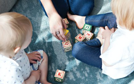 two toddler playing letter cubes