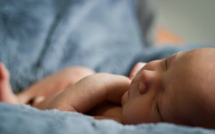 closeup photo of baby on blue blanket