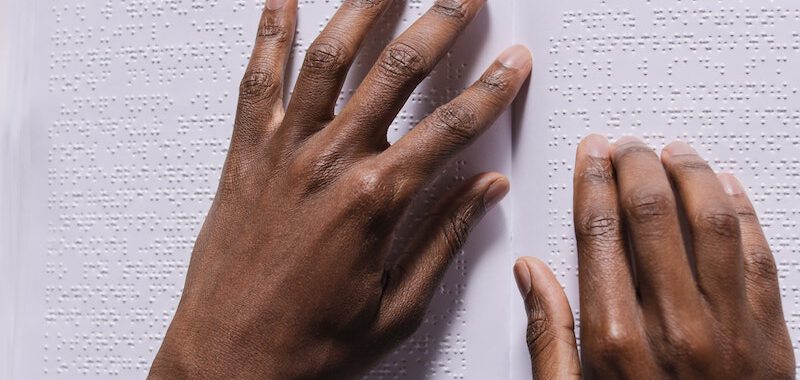 A Person Reading Book Using Braille