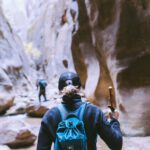 two people hiking in the middle of huge rock formations