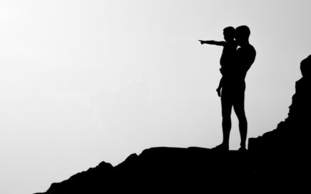 silhouette of man carrying child