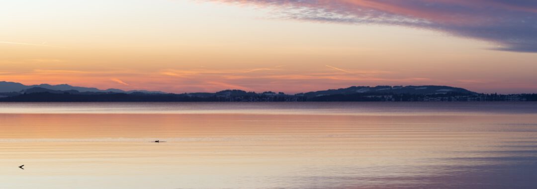 a large body of water with mountains in the background